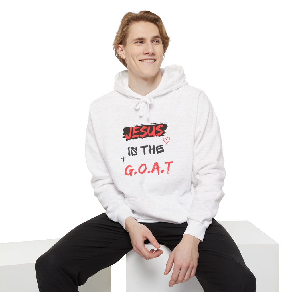 Person wearing a white hoodie with 'JESUS is the G.O.A.T.' text on a white background
